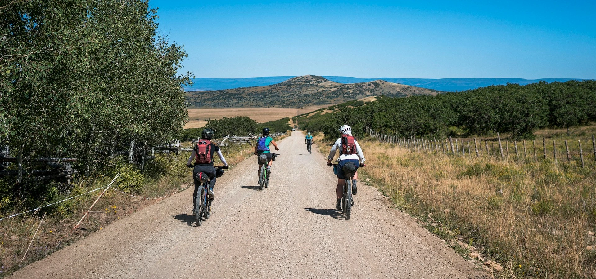 a group of people riding bikes down a dirt road